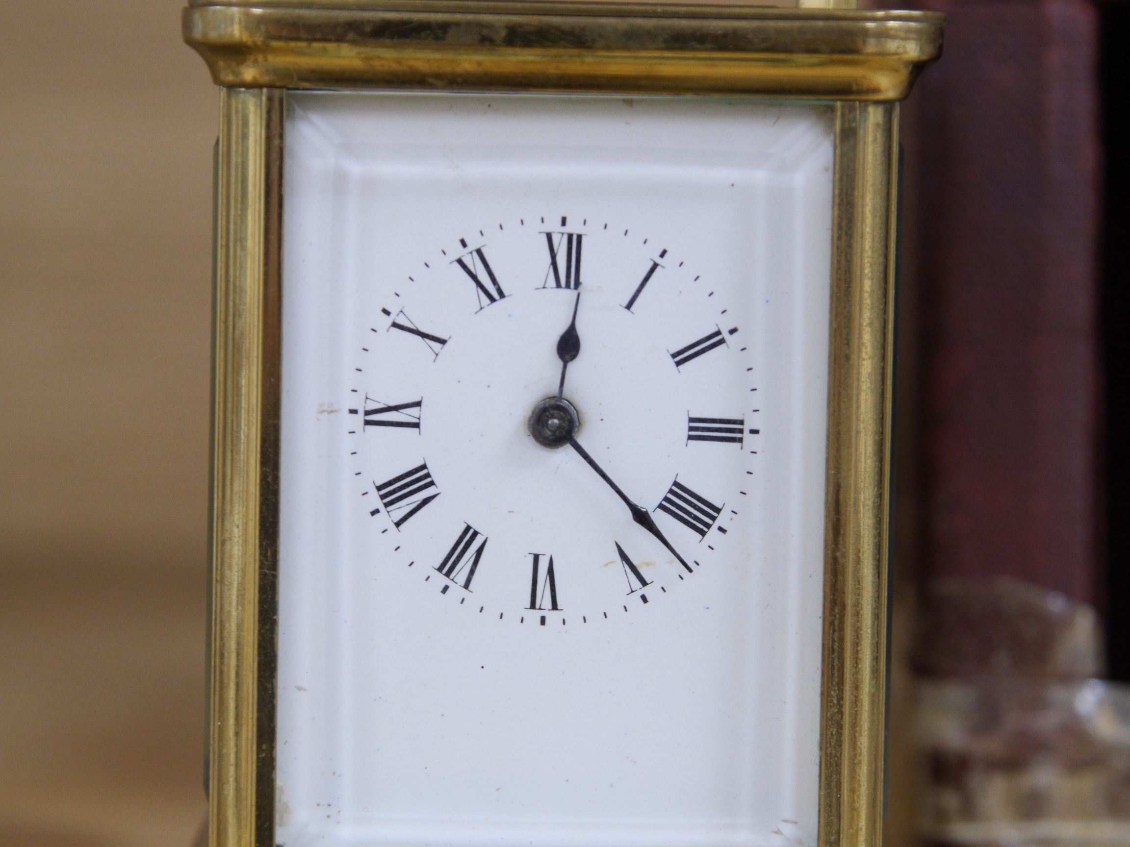 A cased carriage clock, 12cm high including handle. Condition - cased taped at base, clock unknown if it works.